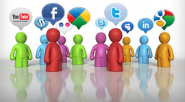 Imagem. Desenho de pessoas estilizadas de várias cores entre elas: vermelho, verde, azul, laranja e lilás. As pessoas estão de pé e, em cima de cada uma delas, a figura de uma balão com os símbolos de algumas redes sociais como twitter, facebook e youtube.