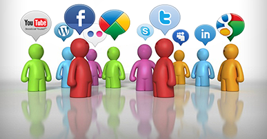 Imagem. Desenho de pessoas estilizadas de várias cores entre elas: vermelho, verde, azul, laranja e lilás. As pessoas estão de pé e, em cima de cada uma delas, a figura de uma balão com os símbolos de algumas redes sociais como twitter, facebook e youtube. 