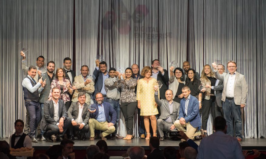 Foto: Finalistas do prêmio DES 2019 no palco segurando troféus.