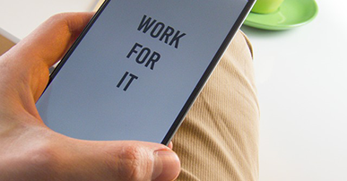 Imagem: homem segurando celular escrito "work fo it". características do profissional de comunicação.