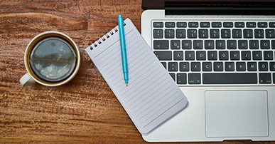 Imagem: notebook com uma xícara de café e bloco de notas. Cursos.