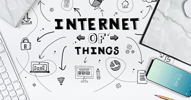 Imagem: mesa com computador e a frase Internet of Things. IoT.