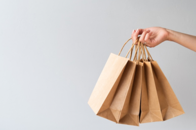 Imagem: fundo cinza com mão segurando sacolas de papel. ciclo de vendas..