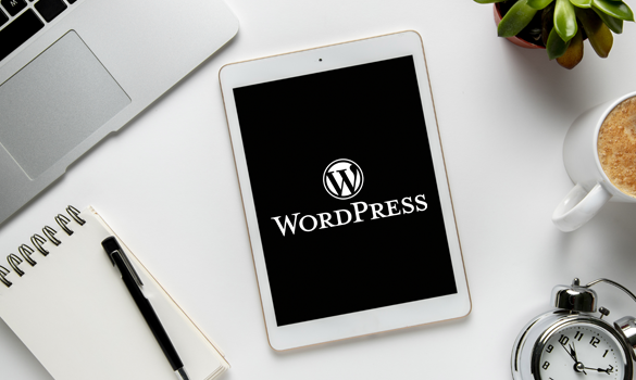 Imagem: tablet em cima de uma mesa branca, com o logo do WordPress no visor.